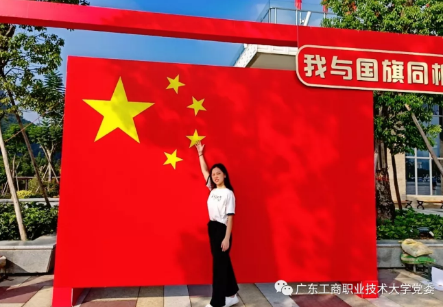 图为入党学生林爱瑜与国旗合影